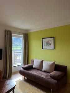 a living room with a brown couch and a green wall at Villa Theresa in Kaprun