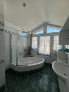 a bathroom with a large tub and a sink at Villa Theresa in Kaprun