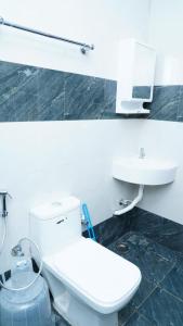 コダイカナルにあるLeos Denの白いトイレと洗面台のあるバスルーム +23枚の写真