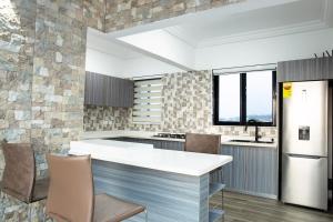a kitchen with a white counter and chairs at K's Place in Accra