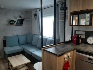 Una sala de estar con un sofá azul y una mesa. en Le Bora Bora 202, en Saint-Jean-de-Monts