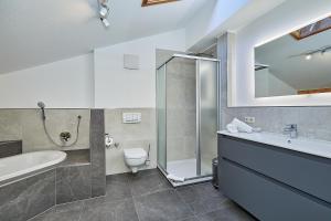 a bathroom with a tub and a toilet and a sink at Gästehaus Angerer in Reit im Winkl +39 photos