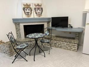a living room with a fireplace with a table and chairs at Villa Dolce Vita rooms in Castelluzzo +69 photos