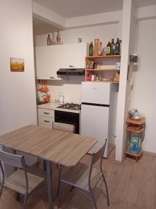 a small kitchen with a wooden table and a stove at Beach 10 in Lido Adriano