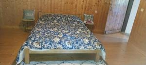 a bed with a blue and white comforter in a room at L'Essentiel in Arbusigny