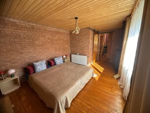 a bedroom with a bed and a brick wall at Rubicon Cabins in Secăria