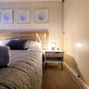 アントファガスタにあるDepartamento ejecutivo 2 habitaciones Centralのベッドとナイトスタンド付きのテーブルがある寝室