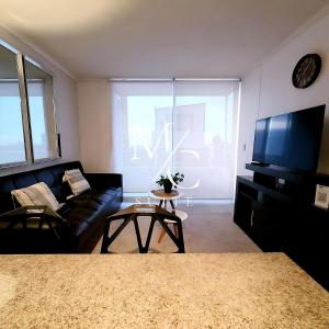 アントファガスタにあるDepartamento ejecutivo 2 habitaciones Centralのリビングルーム(黒いソファ、テレビ付) +7枚の写真