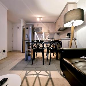 アントファガスタにあるDepartamento ejecutivo 2 habitaciones Centralのテーブルと椅子のあるキッチンとダイニングルーム