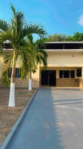 a building with two palm trees in front of it at Casa de Temporada em Iranduba in Iranduba