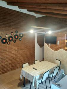 a table and chairs in a room with a brick wall at Un lugar en el mundo in Mina Clavero