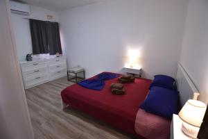a bedroom with a bed with a red blanket and blue pillows at Sea Breeze Nest in St Paul's Bay +28 photos