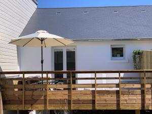 Un patio con una sombrilla y una mesa y sillas. en Chez Rose, Terrasse Plein Sud!, en Donville-les-Bains 8 fotos más