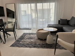 a living room with a couch and a table at -Mari- Cozy Stay at Engomi Near UNIC in Nicosia