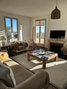 Una sala de estar con un sofá y una mesa de café. en Exceptionnel, 130 m2, vue aérienne sur Paris, en Ville-dʼAvray