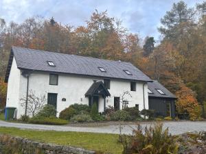 a white house with a black roof at Aldernaig Mill in Invergarry