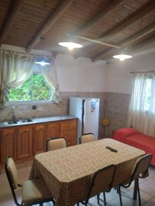a kitchen with a table with chairs and a refrigerator at Un lugar en el mundo in Mina Clavero