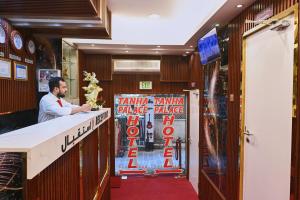 a man standing at a bar in a restaurant at Tanha Palace Hotel in Dubai