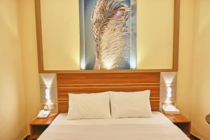 a bedroom with a bed with a picture above it at Tanha Palace Hotel in Dubai +23 photos