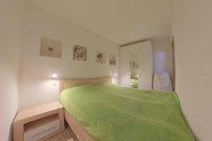 een slaapkamer met een groen bed en een spiegel bij Apartment 238 in Hohegeiß