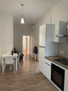 una cucina con un tavolo e un frigorifero bianco di Tarantè a Napoli