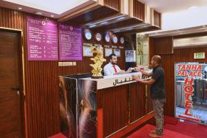 two men standing at a counter in a restaurant at Tanha Palace Hotel in Dubai