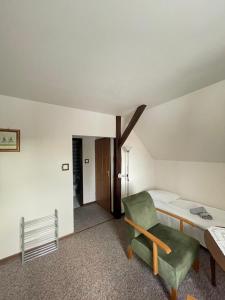 a room with a bed and a green chair at Willa Szwadron in Łańcut
