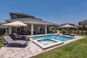 基西米Elegant Home Near Disney With Private Pool And Waterpark Resort Access At Encore Resorts Reunion - 391Fl的后院设有带椅子和遮阳伞的游泳池
