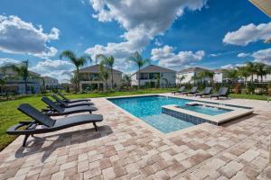 a pool with lounge chairs next to a yard with houses at Grand Home Near Disney With Private Pool, Media And Themed Rooms With Waterpark & Resort Access At Encore Resorts Reunion - 360Bu in Orlando