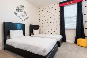 two beds in a room with black and white at Grand Home Near Disney With Private Pool, Media And Themed Rooms With Waterpark & Resort Access At Encore Resorts Reunion - 360Bu in Orlando