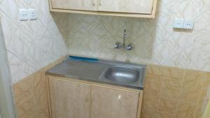 a small kitchen with a sink in the corner at ناصر علي أبودهش للشقق المخدومة in Wadi Al Dawasir