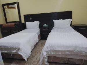 two beds sitting next to each other in a bedroom at ناصر علي أبودهش للشقق المخدومة in Wadi Al Dawasir