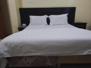 a large bed with white sheets and pillows at ناصر علي أبودهش للشقق المخدومة in Wadi Al Dawasir