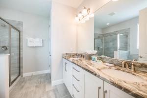Un baño con dos lavabos y un espejo grande. en Fabulous Home With Air Hockey, Media Room And Waterpark & Resort Access Near Disney At Encore Resorts Reunion - 290Fl, en Kissimmee