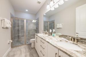 Un baño con dos lavabos y una ducha. en Fabulous Home With Air Hockey, Media Room And Waterpark & Resort Access Near Disney At Encore Resorts Reunion - 290Fl, en Kissimmee