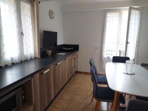 a kitchen with a table and a dining room at Colchique in Le Mas