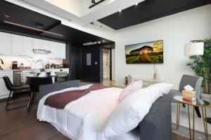 Un dormitorio con una gran cama blanca y una cocina. en Sleek 2BR On Rvrwalk Gym Parking Near Conv Ctr, en San Antonio