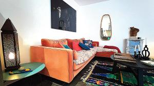 a living room with an orange couch and a mirror at Villa Dionysos in Plaka