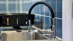 a sink with a faucet in a kitchen at Large Modern Home Near Barking Station With SuperFast 1gbps Wi-Fi & Free Parking in Barking +64 photos