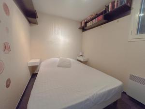 a small room with a white bed in it at Charmante Maison, Terrasse,parking domaine du pins, piscine in Fréjus +2 photos