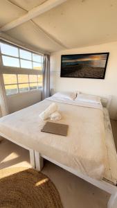 a large white bed in a room with a window at Salty House Cabo Polonio in Cabo Polonio