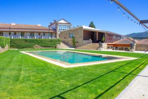 a swimming pool in the yard of a house at Hotel Rural Casa de Samaioes in Chaves