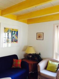 a living room with a blue couch and a chair at Dune Bep in Schiermonnikoog