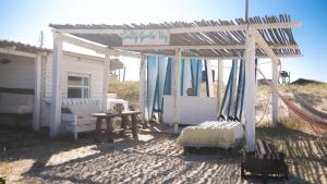 a pergola with a bed and a table and a table at Salty House Cabo Polonio in Cabo Polonio