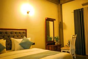 a bedroom with a bed and a mirror and a chair at Monkey Banana Villa in Galle