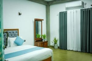 a bedroom with a large bed and a mirror at Monkey Banana Villa in Galle +14 photos