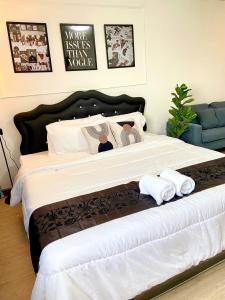 a bedroom with a large bed with towels on it at Impact Arena Condo 6fl by GoodRoom24 in Ban Song Hong