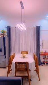 a dining room with a table and chairs and a light fixture at Evelina House in Boma la Ngombe