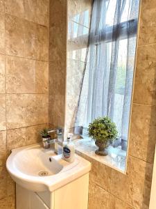 a bathroom with a sink and a window at 4 ensuite Bedroom Entire House Sleeps 10 Driveway Parking near Coventry Univesity and City Center in Coventry +32 photos