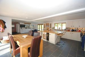 a kitchen with a wooden table and a dining room at Exmoor Farmhouse in Bampton